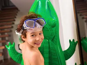 Foto von Diego, der ein aufblasbares Krokodil hält.